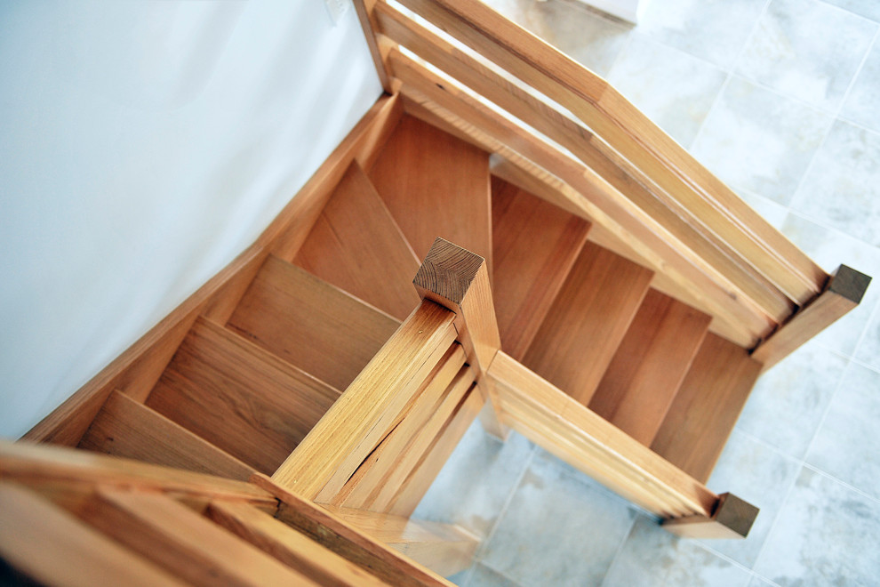 Exempel på en liten modern l-trappa i trä, med öppna sättsteg och räcke i trä