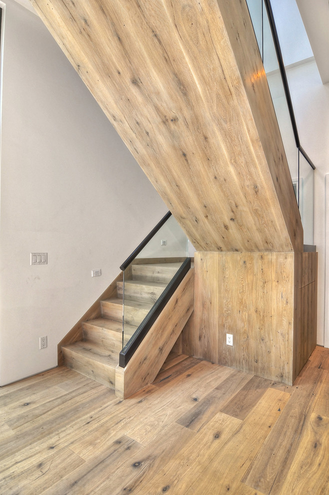 Large rustic wood u-shaped staircase in Orange County with wood risers.