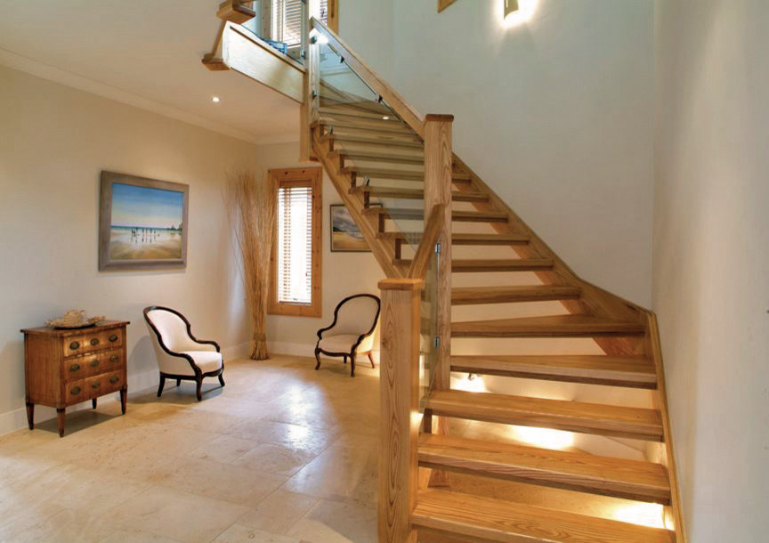 Свежая идея для дизайна: изогнутая лестница в стиле неоклассика (современная классика) с деревянными ступенями и деревянными перилами без подступенок - отличное фото интерьера