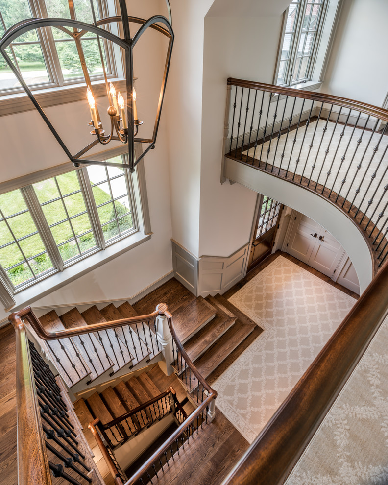 Идея дизайна: большая п-образная лестница в классическом стиле с деревянными ступенями, крашенными деревянными подступенками и металлическими перилами