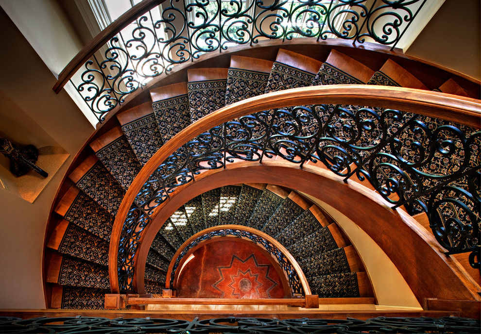 Foto de escalera curva clásica grande con escalones de madera