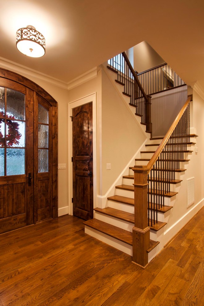 Свежая идея для дизайна: огромная п-образная лестница в классическом стиле с деревянными ступенями, крашенными деревянными подступенками и металлическими перилами - отличное фото интерьера