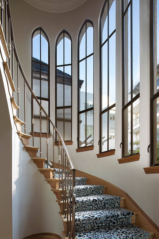 Foto de escalera curva tradicional de tamaño medio con escalones de madera y contrahuellas de madera