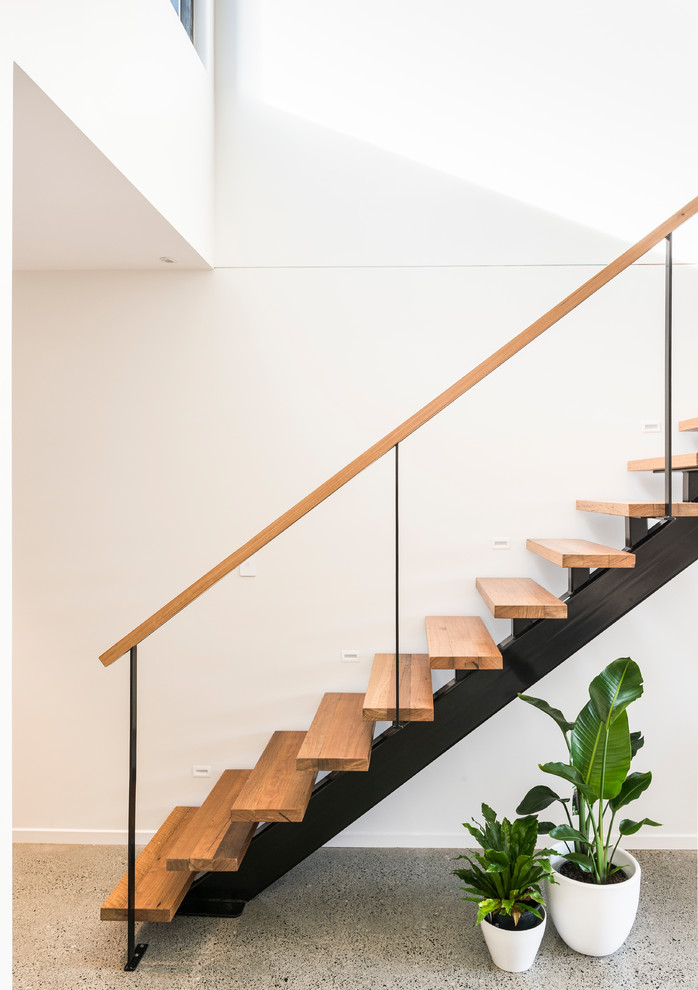 Imagen de escalera recta contemporánea de tamaño medio sin contrahuella con escalones de madera y barandilla de metal
