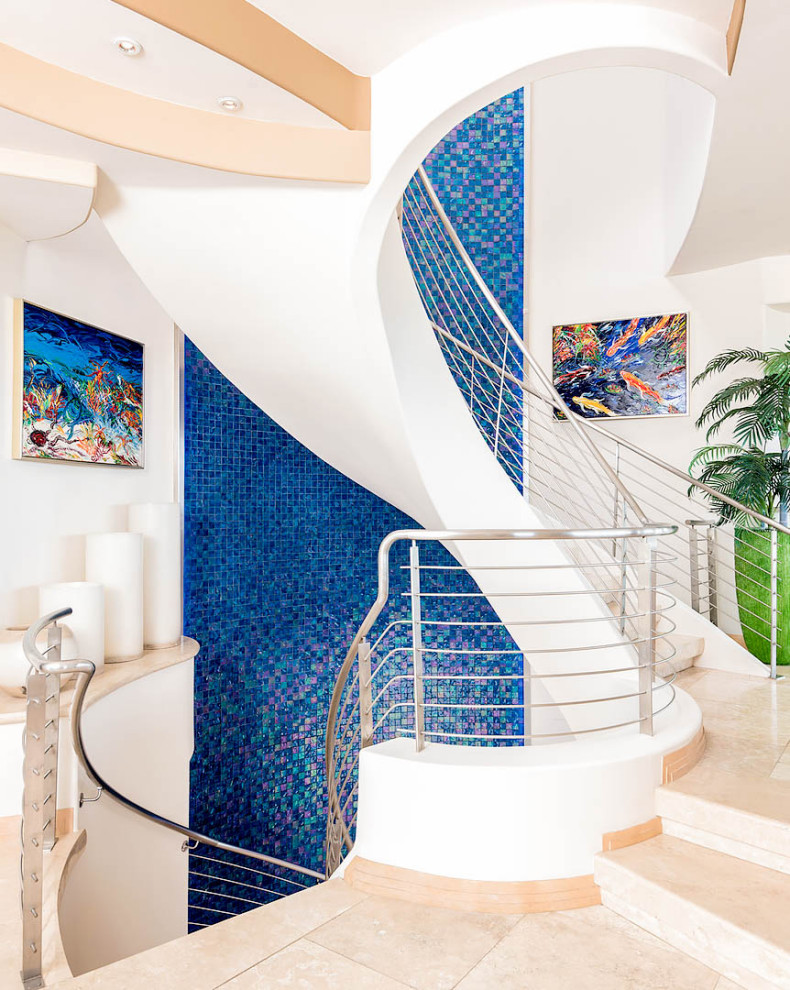 Пример оригинального дизайна: большая винтовая лестница в современном стиле с металлическими перилами, ступенями из плитки и подступенками из плитки