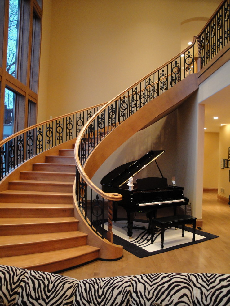 Inspiration pour un très grand escalier courbe traditionnel avec des marches en bois et des contremarches en bois.