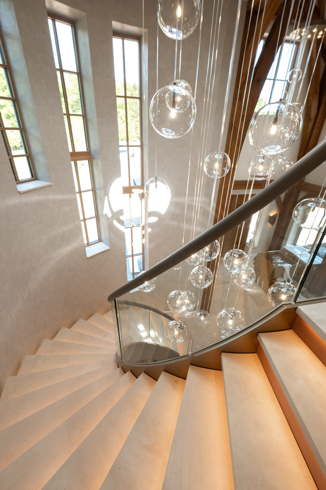 Aménagement d'un escalier courbe contemporain avec des marches en métal et un garde-corps en verre.