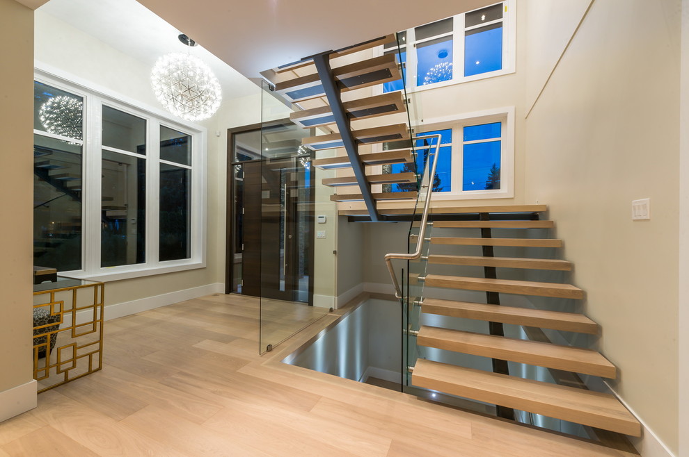Photo of a large contemporary wood l-shaped staircase in Vancouver with open risers.