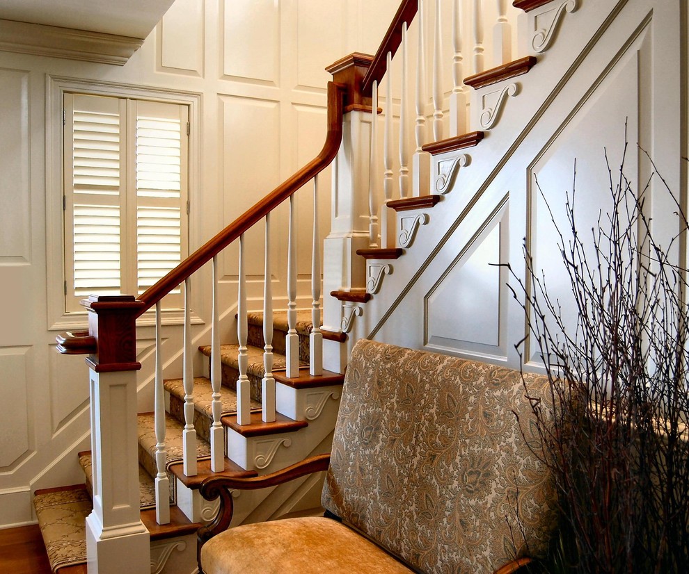Imagen de escalera en L clásica de tamaño medio con escalones de madera, contrahuellas de madera y barandilla de madera