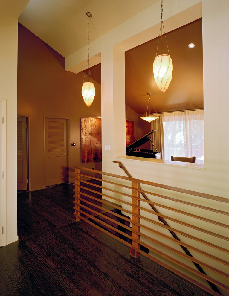 Foto de escalera recta minimalista de tamaño medio con escalones enmoquetados, contrahuellas enmoquetadas y barandilla de metal