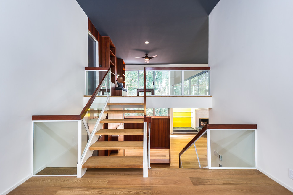 Photo of a large retro wood u-shaped staircase in Los Angeles with open risers.