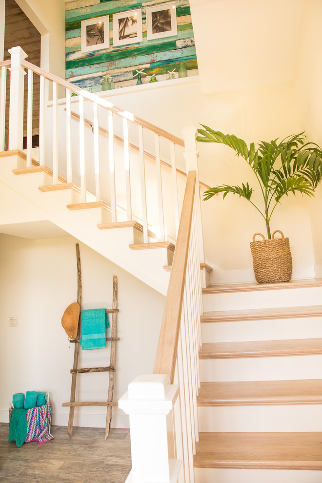 Photo of a small beach style wood l-shaped wood railing staircase in Hawaii with painted wood risers.
