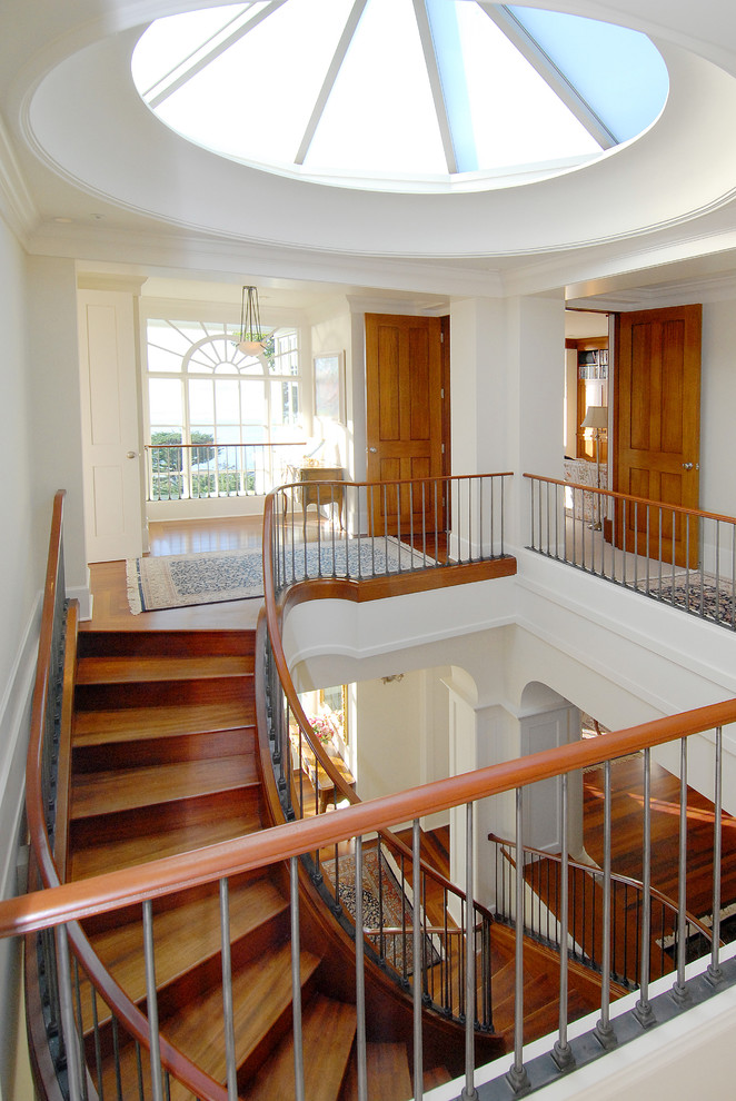 Свежая идея для дизайна: изогнутая деревянная лестница в классическом стиле с деревянными ступенями - отличное фото интерьера