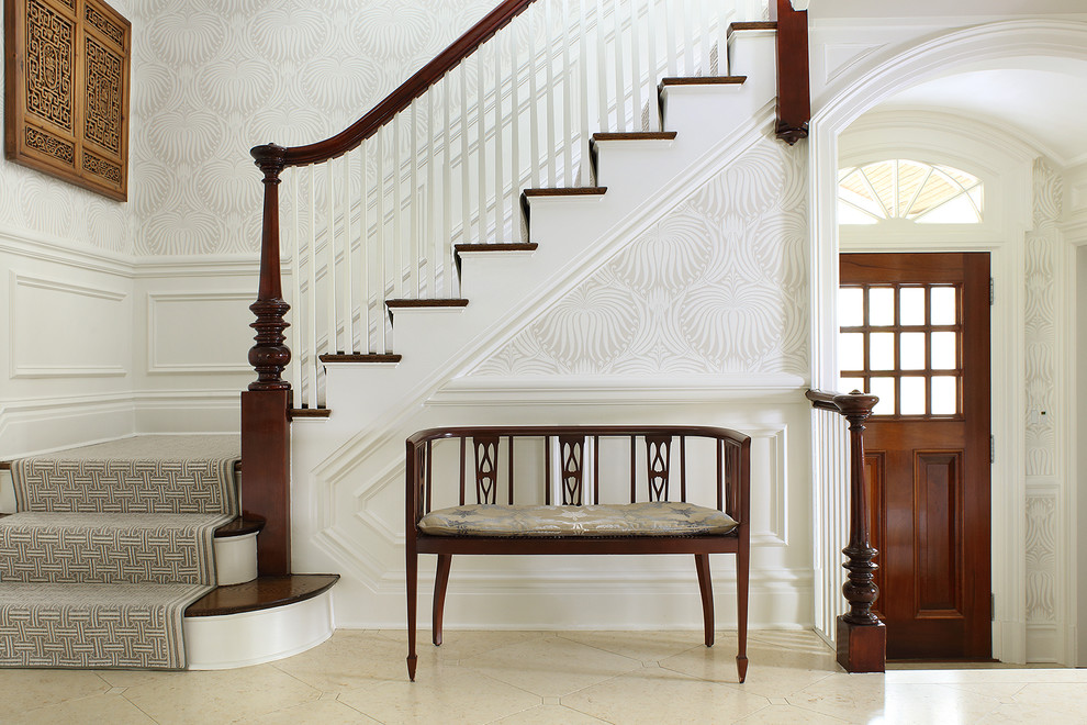 На фото: угловая лестница среднего размера в классическом стиле с деревянными перилами, деревянными ступенями и крашенными деревянными подступенками
