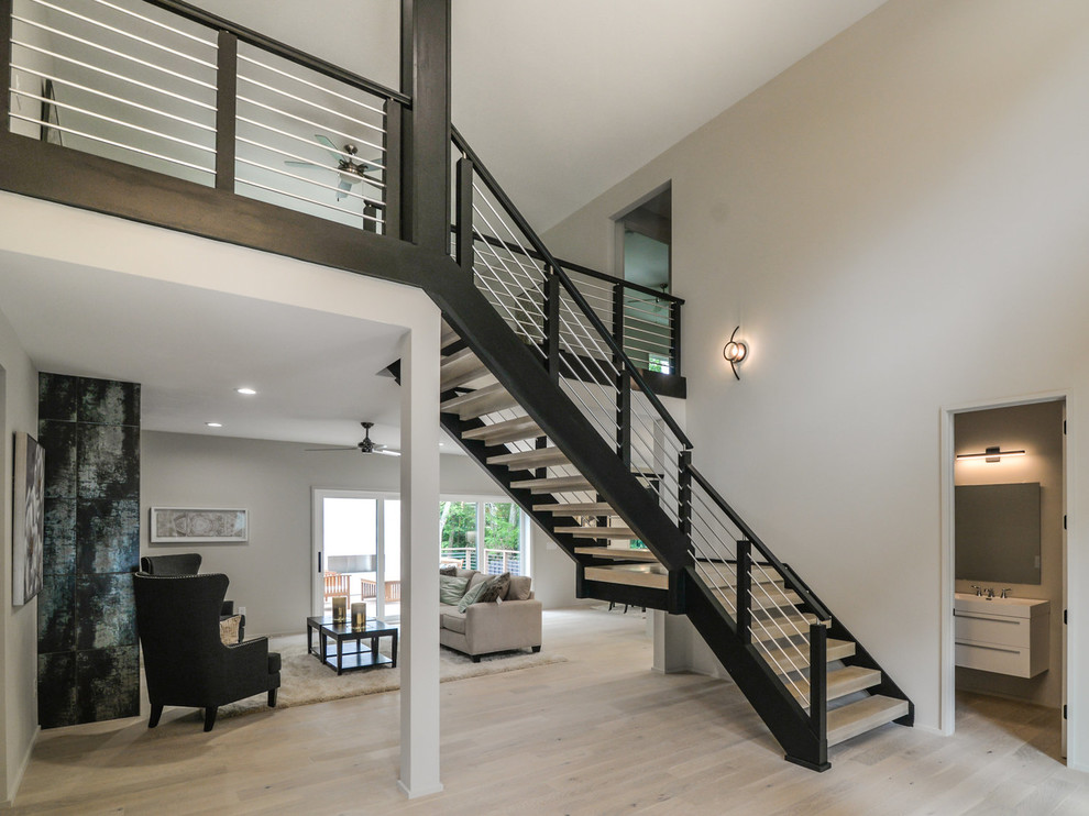Large minimalist wooden floating open and metal railing staircase photo in Charlotte