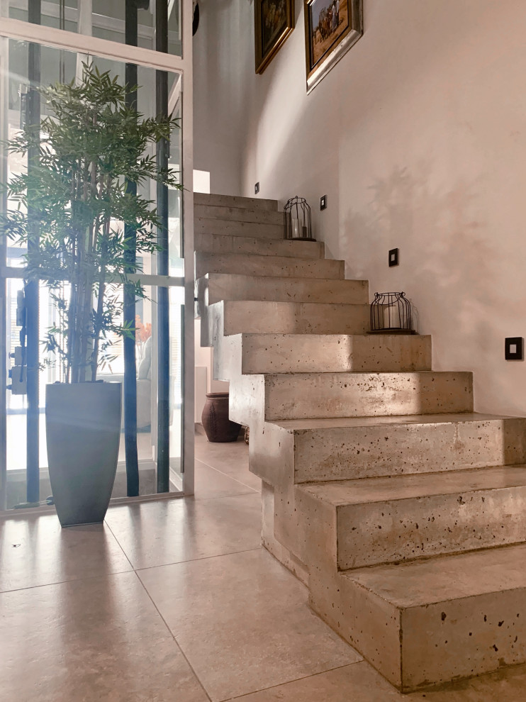 Inredning av en modern mellanstor trappa, med sättsteg i betong och räcke i flera material