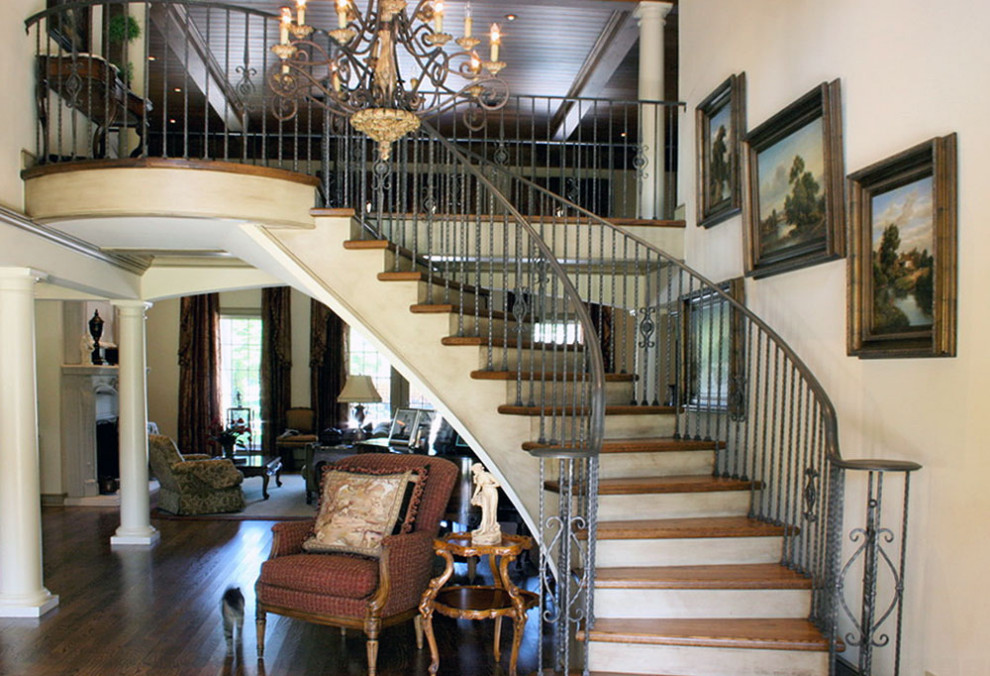 ラグジュアリーな巨大なトラディショナルスタイルのおしゃれな階段 (木の蹴込み板) の写真