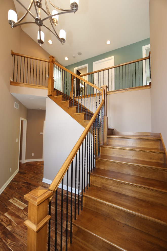 На фото: большая угловая деревянная лестница в классическом стиле с деревянными ступенями с