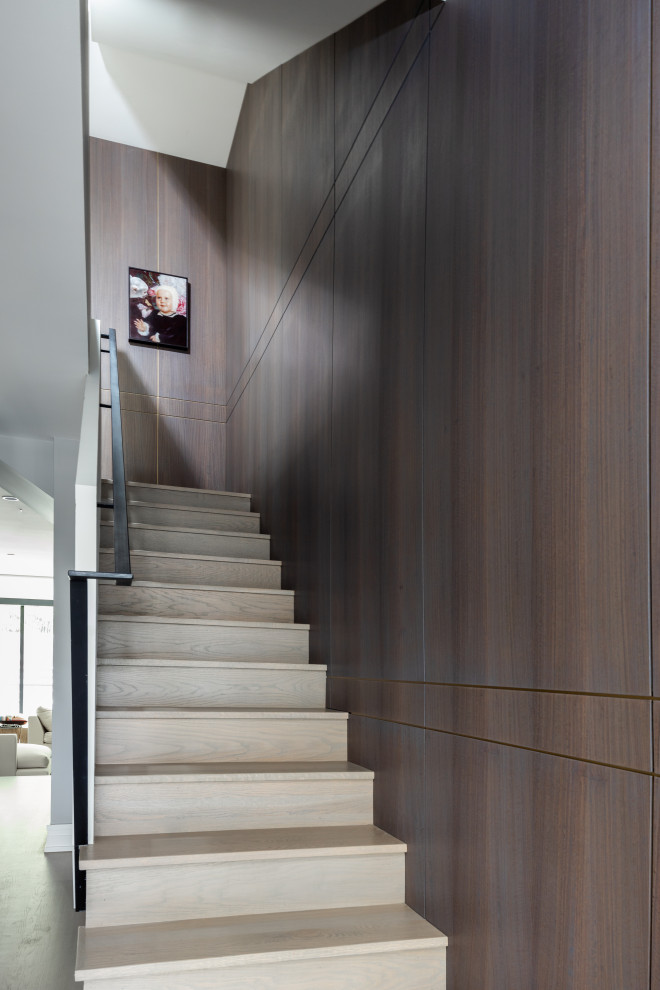 Diseño de escalera en L contemporánea grande con escalones de madera, contrahuellas de madera y barandilla de metal