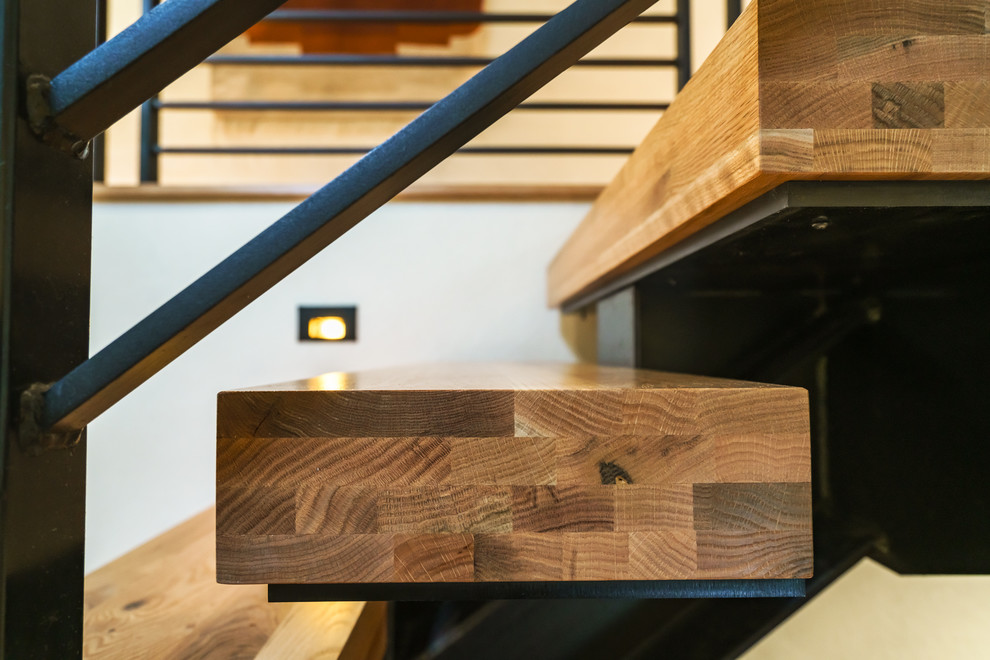 Foto de escalera suspendida contemporánea de tamaño medio sin contrahuella con escalones de madera y barandilla de metal