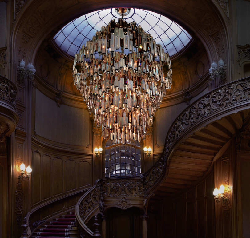На фото: большая изогнутая лестница в викторианском стиле с деревянными перилами с