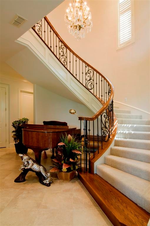 Idées déco pour un grand escalier courbe classique avec des marches en bois et un garde-corps en bois.