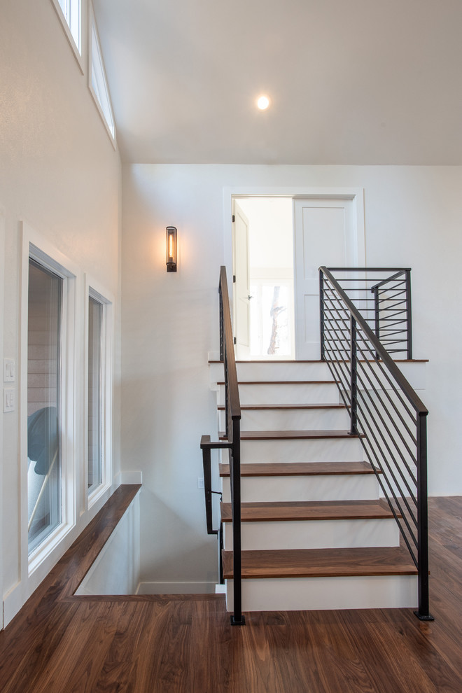 Foto de escalera recta contemporánea de tamaño medio con escalones de metal, contrahuellas de madera pintada y barandilla de metal