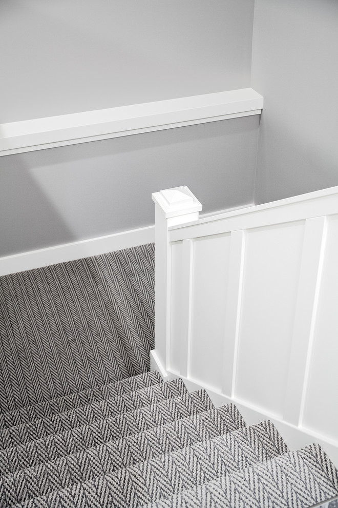 Inspiration pour un escalier minimaliste en U de taille moyenne avec des marches en moquette, des contremarches en moquette et un garde-corps en bois.