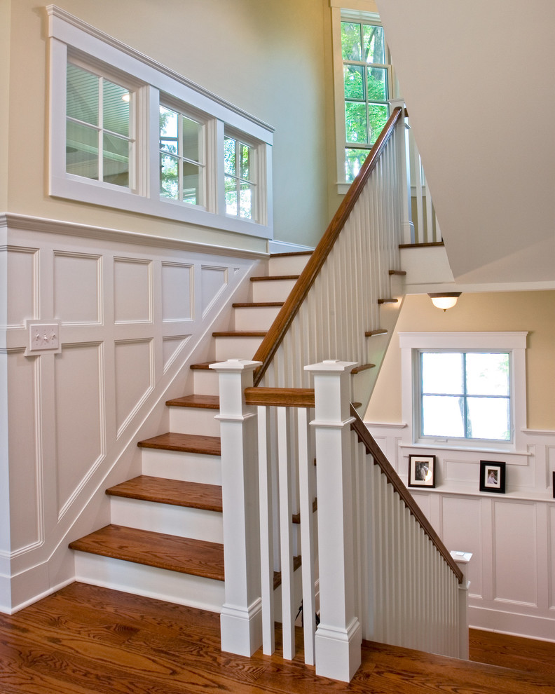 Idée de décoration pour un grand escalier tradition en U avec des marches en bois et des contremarches en bois.