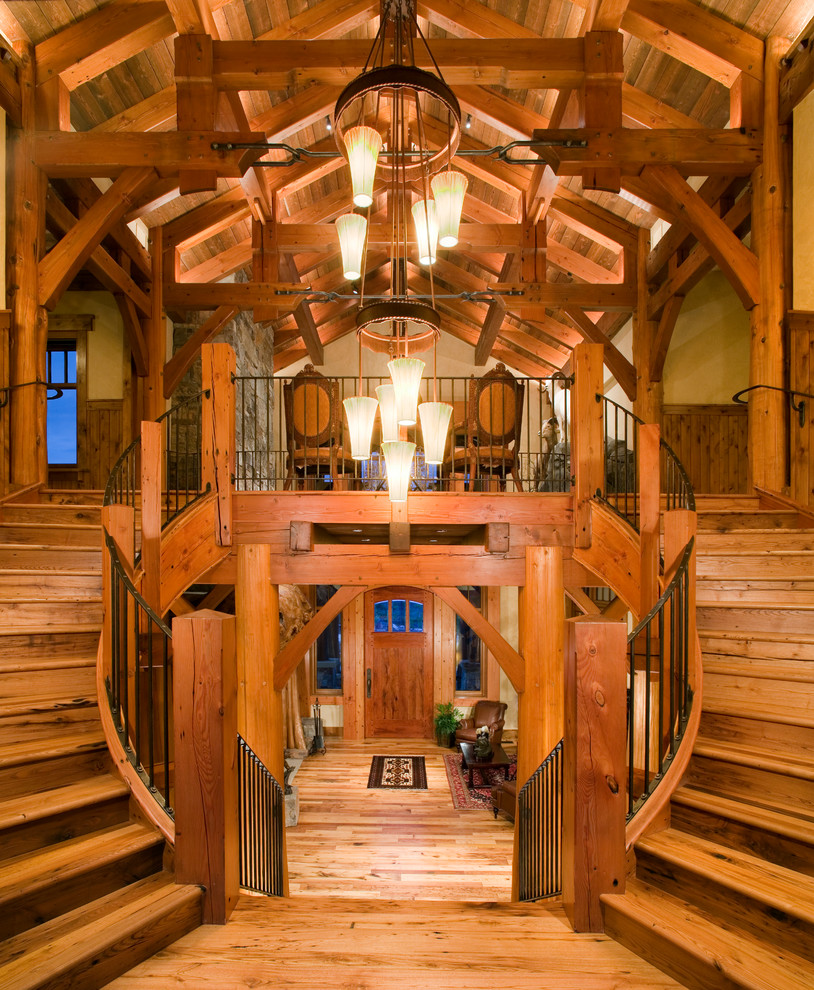 Réalisation d'un très grand escalier courbe chalet avec des marches en bois et des contremarches en bois.