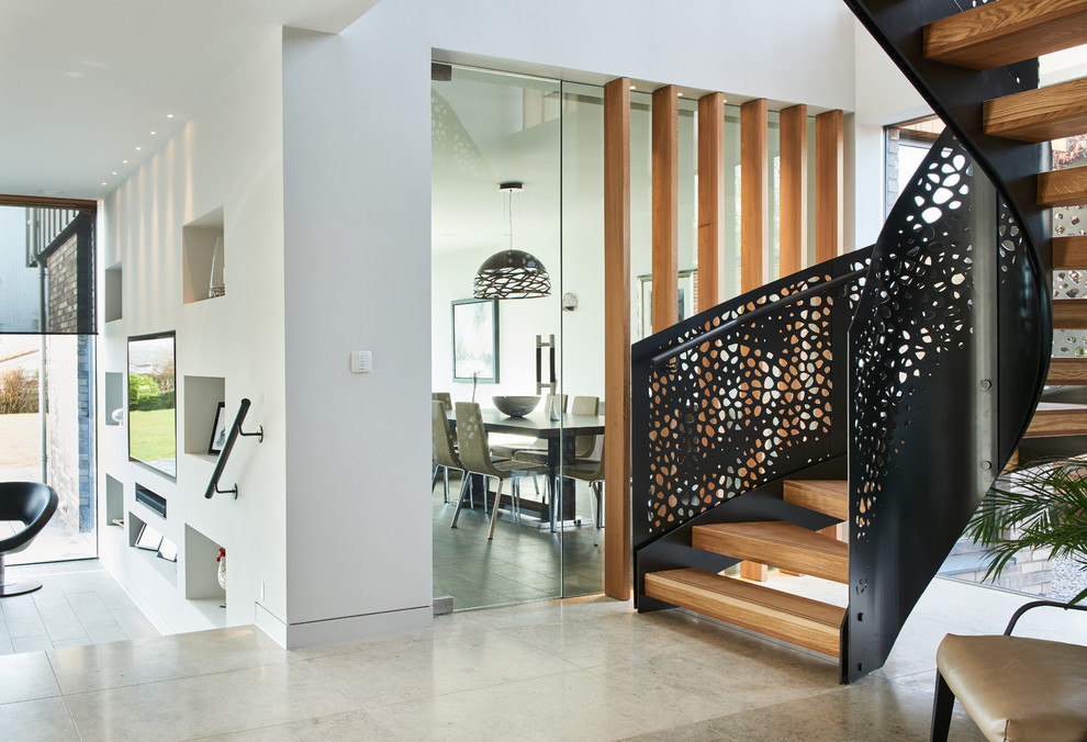 Contemporary wood spiral metal railing staircase in Devon with open risers.