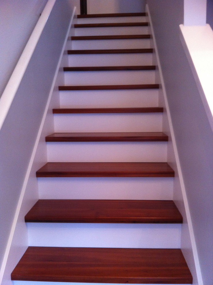 На фото: прямая лестница в современном стиле с деревянными ступенями и крашенными деревянными подступенками с