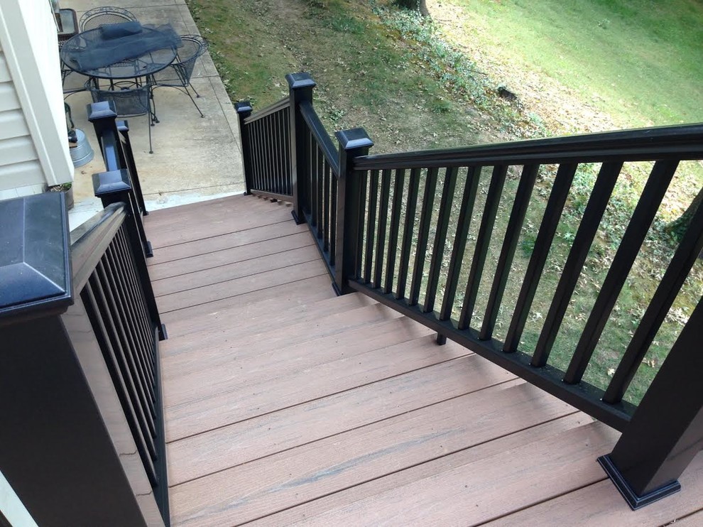 Medium sized traditional wood straight metal railing staircase in St Louis with wood risers.
