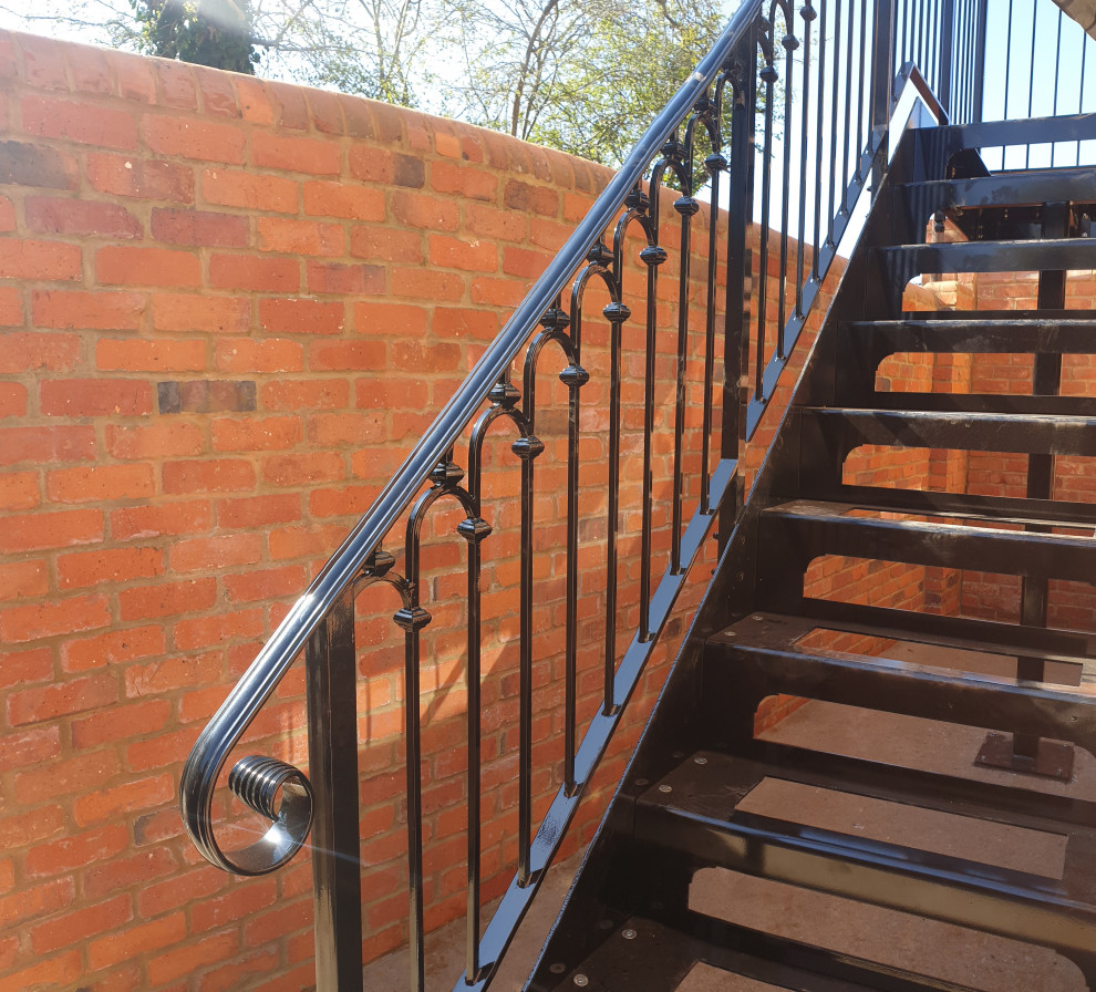 Идея дизайна: прямая лестница среднего размера в викторианском стиле с металлическими ступенями, металлическими перилами и кирпичными стенами без подступенок