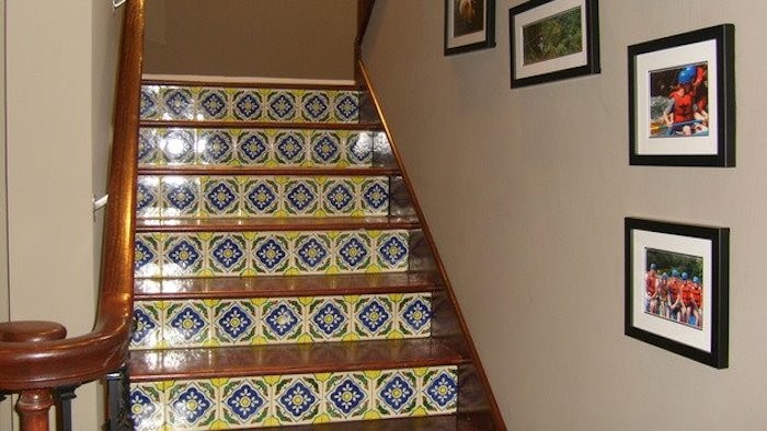 Foto de escalera en L pequeña con escalones de madera y contrahuellas con baldosas y/o azulejos