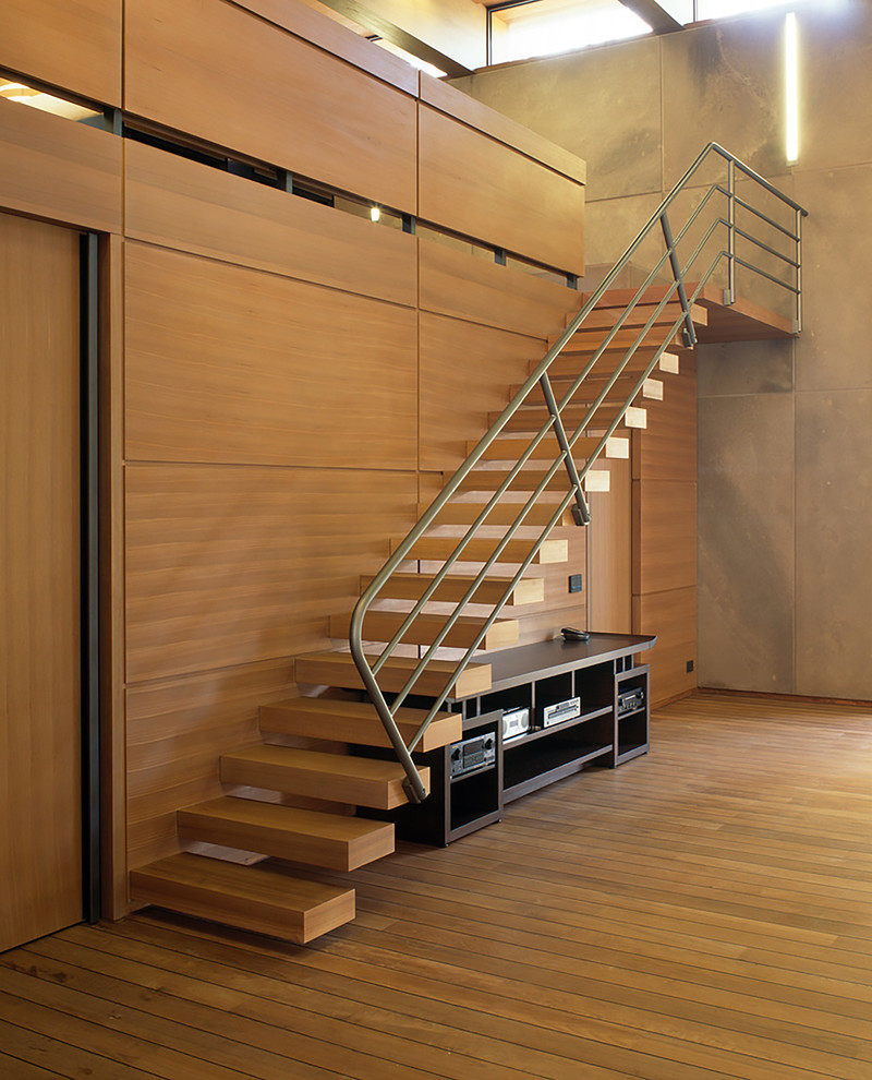 Aménagement d'un grand escalier sans contremarche flottant rétro avec des marches en bois et un garde-corps en métal.