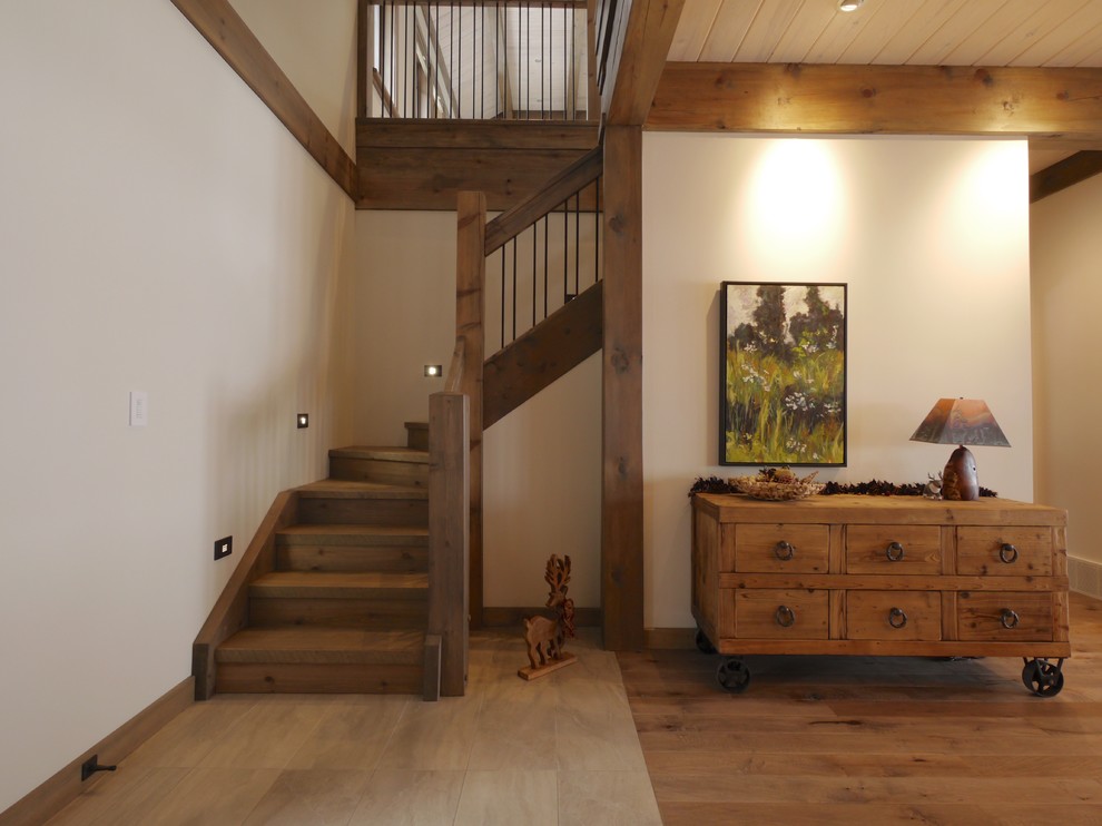 На фото: большая угловая деревянная лестница в стиле рустика с деревянными ступенями и деревянными перилами с
