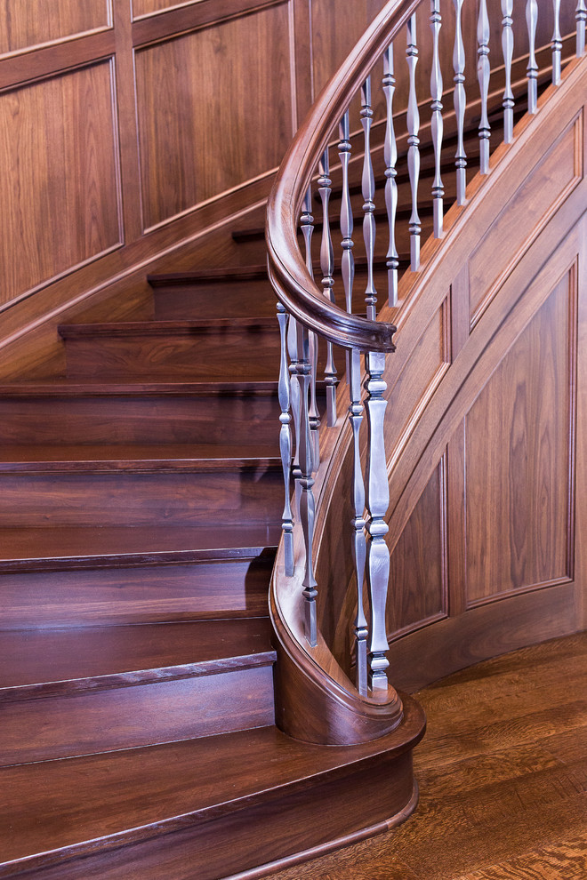 Aménagement d'un très grand escalier courbe classique avec des marches en bois et des contremarches en bois.