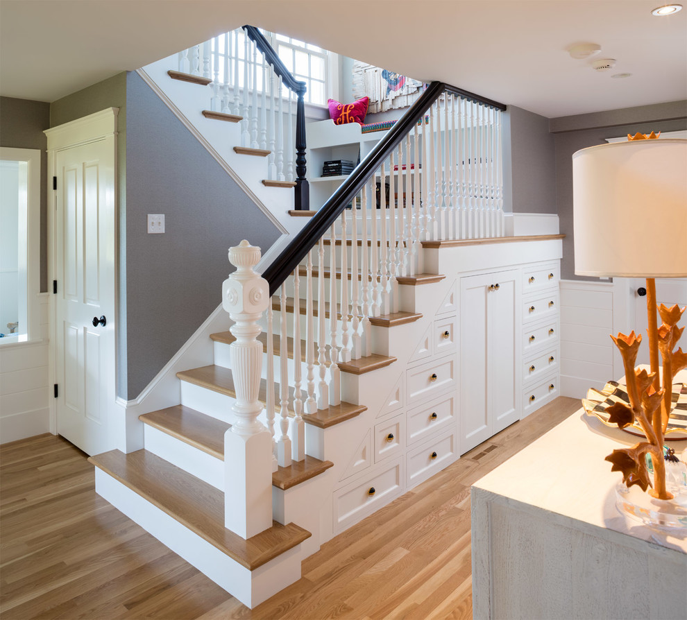 This is an example of a farmhouse staircase in Providence with feature lighting.