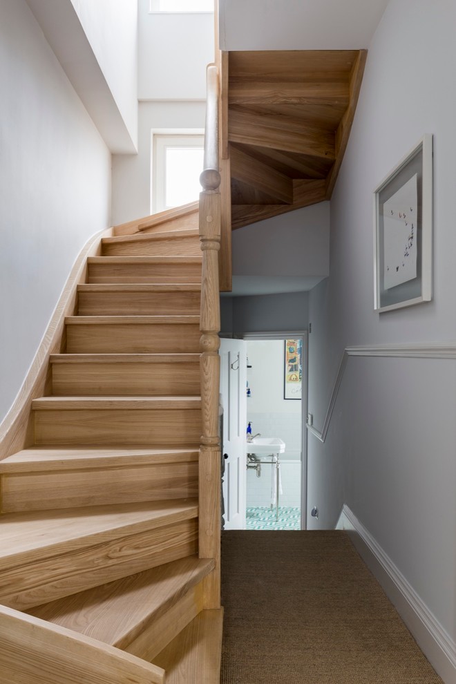 Photo of a medium sized traditional wood u-shaped staircase in London with wood risers.