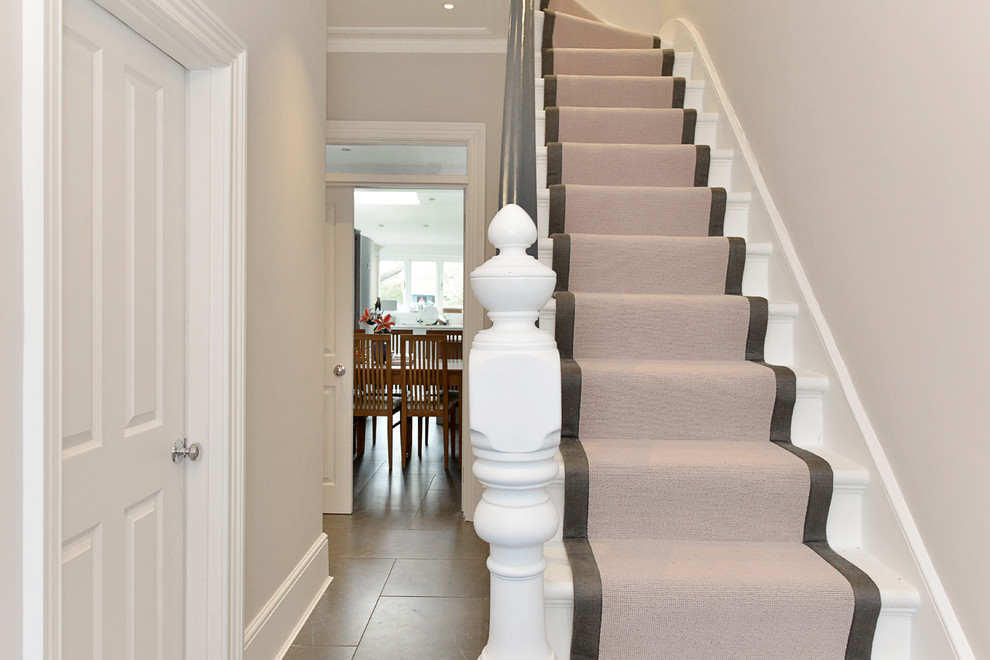 Design ideas for a medium sized victorian carpeted curved wood railing staircase in London with carpeted risers.
