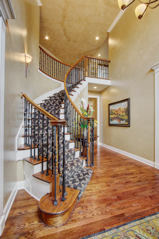 Cette photo montre un grand escalier courbe chic avec des marches en moquette et des contremarches en moquette.