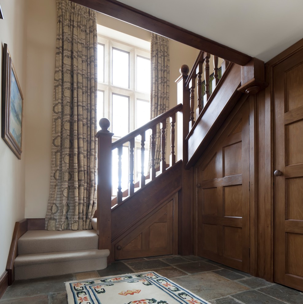 Стильный дизайн: угловая лестница в стиле кантри с ступенями с ковровым покрытием и ковровыми подступенками - последний тренд