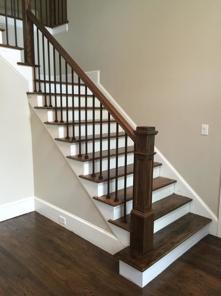 На фото: угловая лестница среднего размера в классическом стиле с деревянными ступенями, крашенными деревянными подступенками и перилами из смешанных материалов с