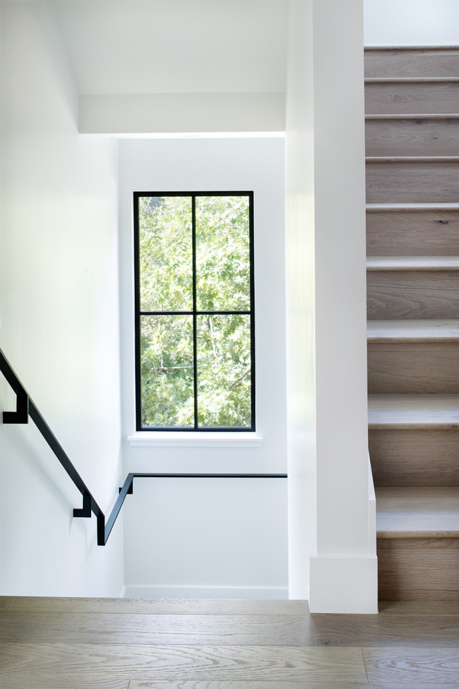 Inspiration for a large farmhouse wooden straight metal railing staircase remodel in Austin with wooden risers