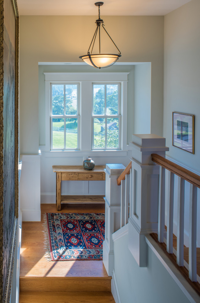 Imagen de escalera recta campestre de tamaño medio con escalones de madera, contrahuellas de madera pintada y barandilla de madera