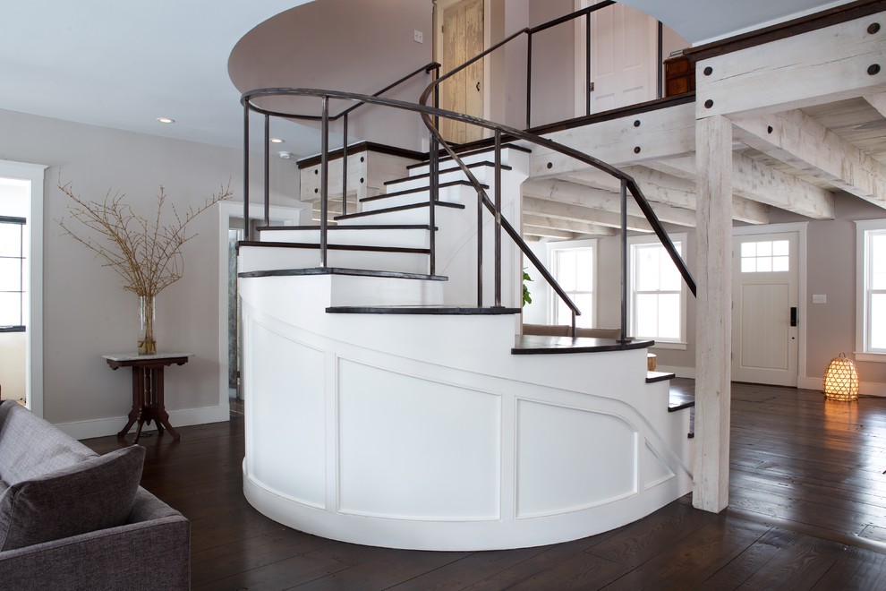 Diseño de escalera curva rústica con contrahuellas de madera pintada y escalones de madera