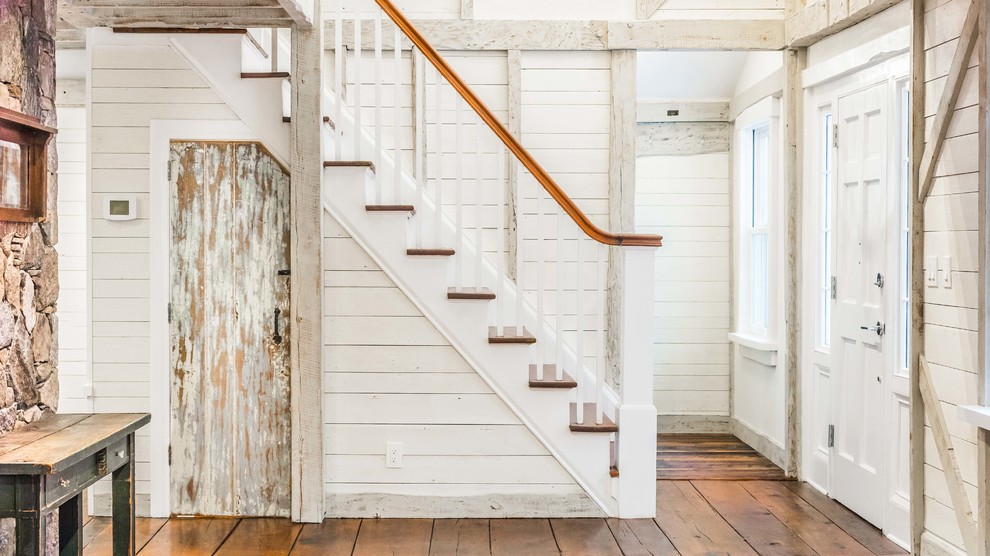 На фото: лестница в стиле кантри с деревянными ступенями, крашенными деревянными подступенками и деревянными перилами