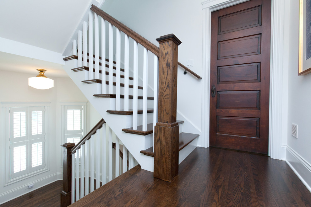 Modelo de escalera en U de estilo de casa de campo de tamaño medio con escalones de madera, contrahuellas de madera y barandilla de madera