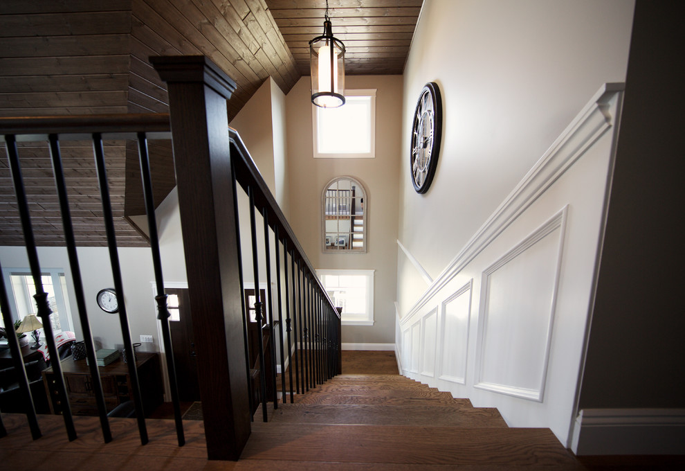 Cette photo montre un grand escalier courbe chic avec des contremarches en bois et des marches en bois.